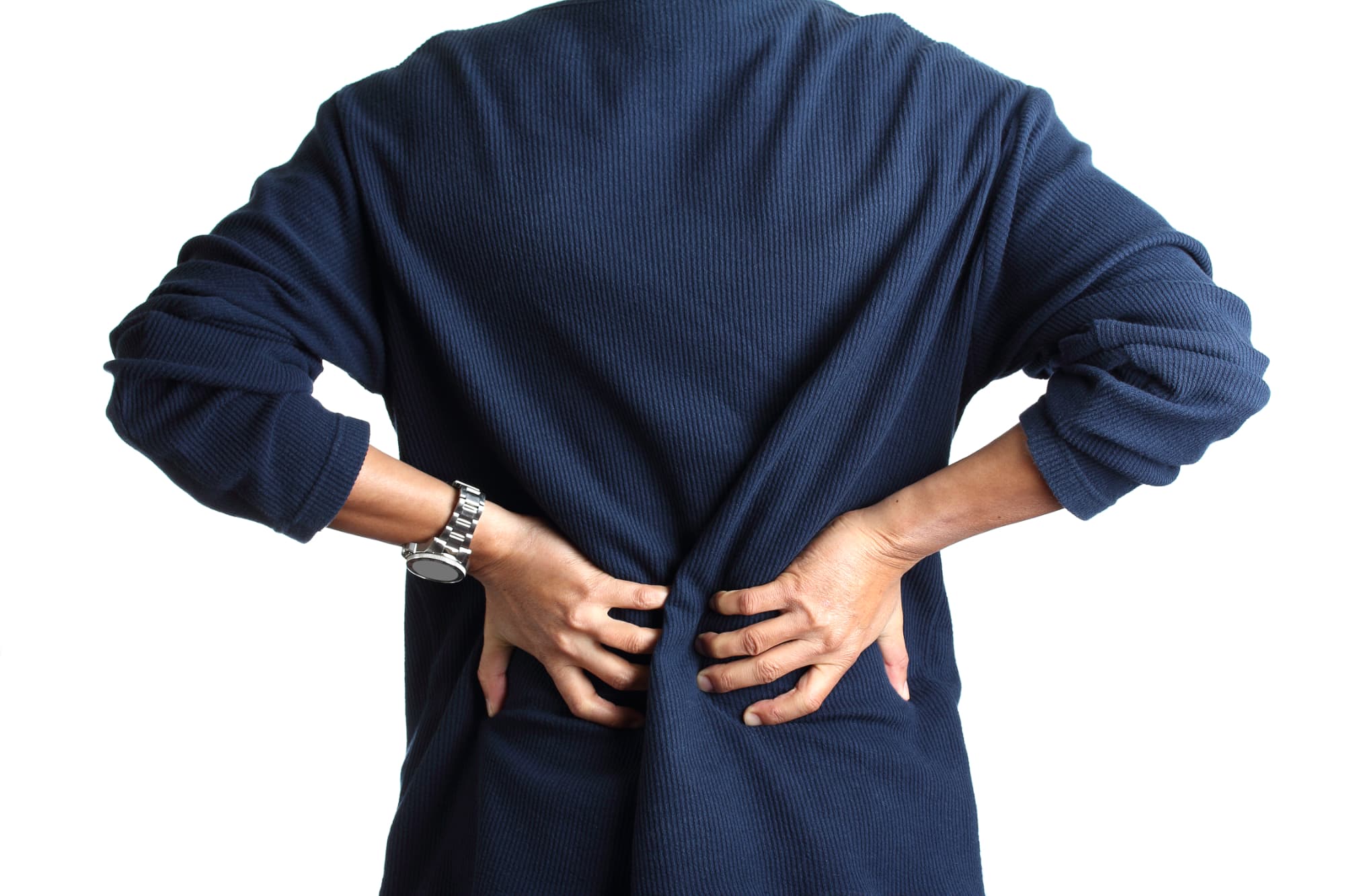 A person wearing a navy blue long-sleeve shirt holds their lower back with both hands, appearing to be in discomfort or pain, possibly seeking back pain compensation. The background is white.